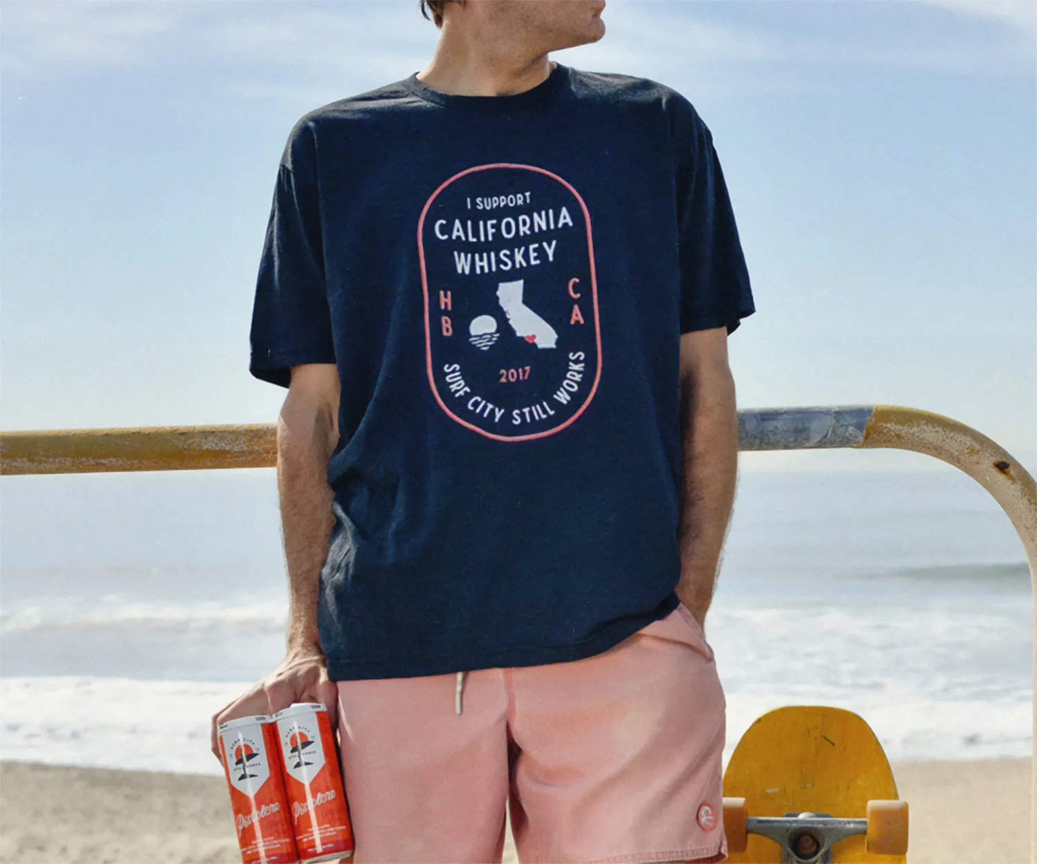 Back of a navy "I support California whiskey" tee at the beach.
