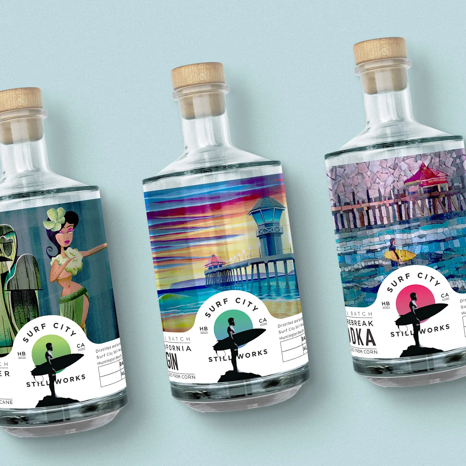 Three Surf City Still Works spirit bottles with illustrated beach-scene labels.